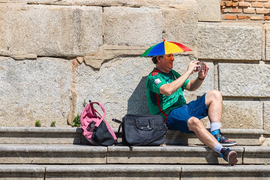 Un hombre se protege del calor con un "sombrero sombrilla". EFE/Ángeles Visdómine