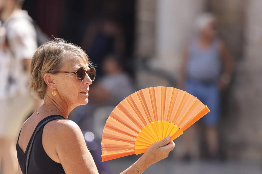 En la imagen, una mujer trata de paliar el calor este viernes usando un abanico en entro de la ciudad deValència. EFE/Ana Escobar
