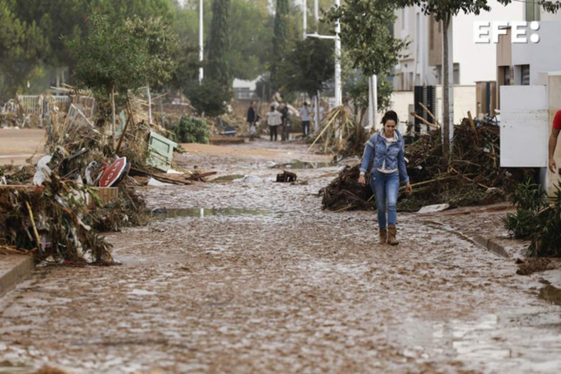 Una mujer camina entre el lodo acumulado por las intensas lluvias de la fuerte Dana, este miércoles en Picaña (Valencia). EFE/Biel Aliño
