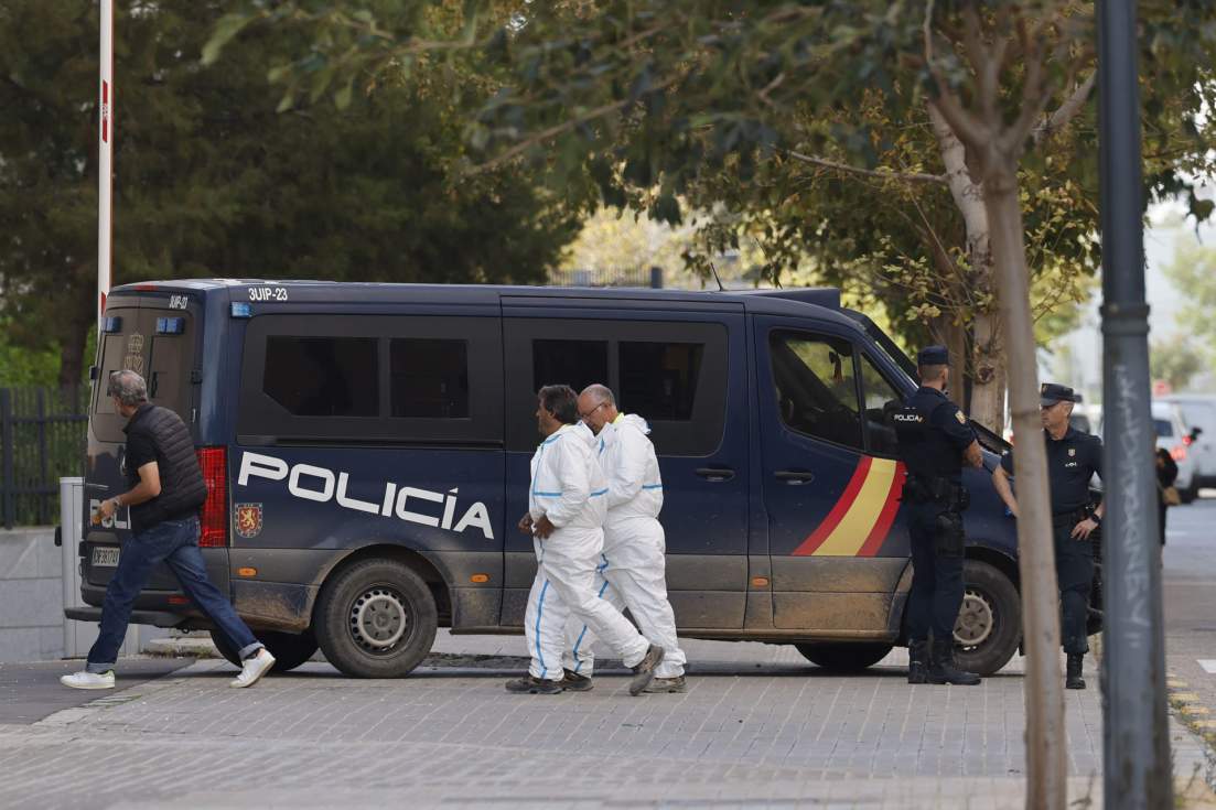 Efectivos de los servicios funerarios junto a un furgón policial. EFE/ Ana Escobar
