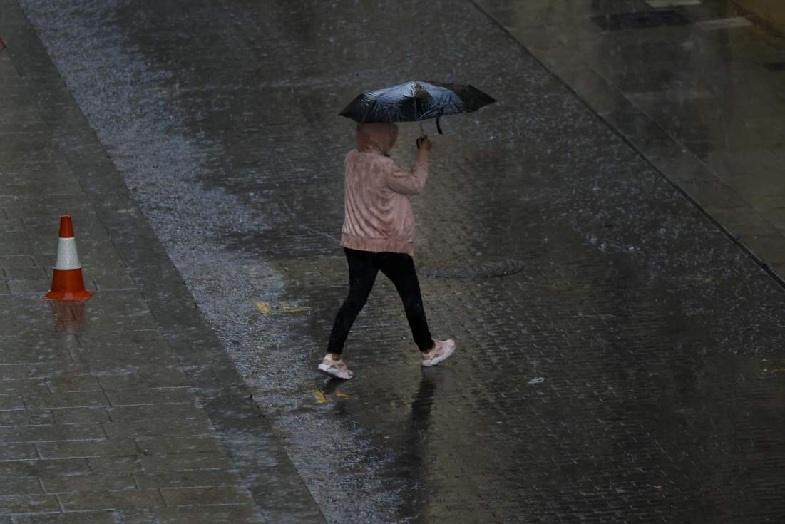 Persona se protege de la lluvia con paraguas. EFE/Biel Aliño